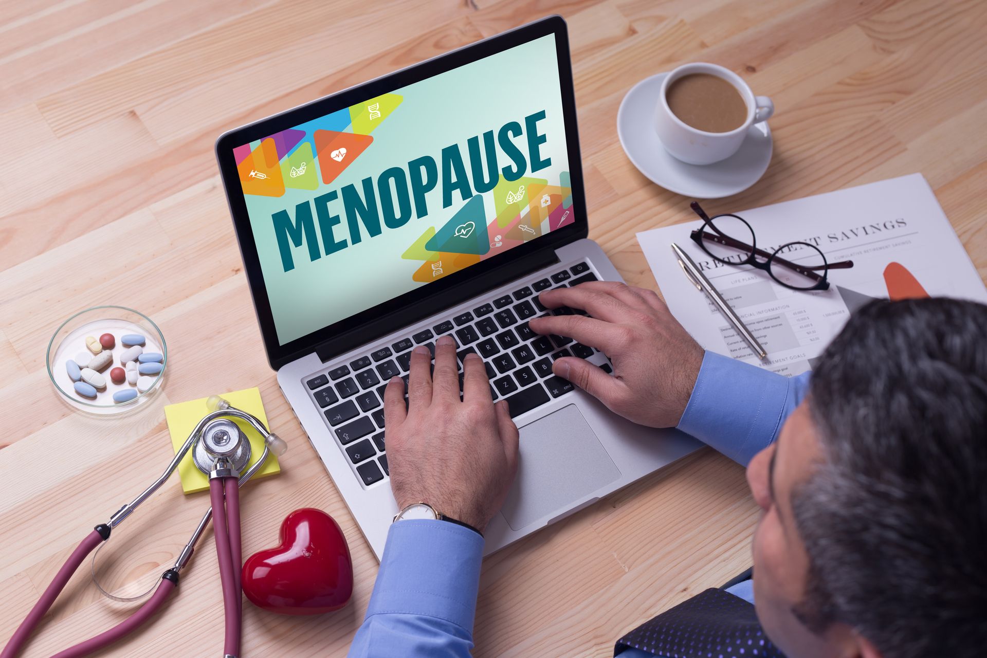 Doctor working on a laptop and MENOPAUSE on his screen